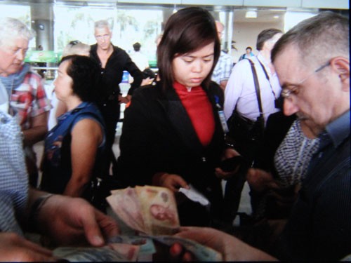 Sau khi bị lật tẩy, nhân viên Saigon Air hoàn lại tiền cho du khách Pháp  trước sảnh sân bay Tân Sơn Nhất - Ảnh chụp lại ảnh của du khách Pháp