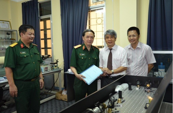 Thiếu tướng Vũ Thanh Hải (trái) nhận hồ sơ từ GS.TS KH Dương Ngọc Hải.