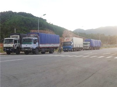 Xe tải và container chờ “nuốt” hàng lậu ngoài cổng kiểm soát.